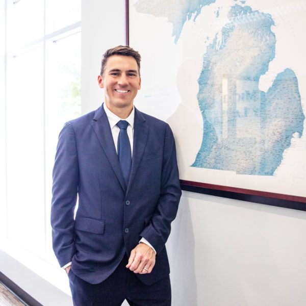 Photo of Personal Injury Attorney David Givskud smiling in front of State of Michigan map