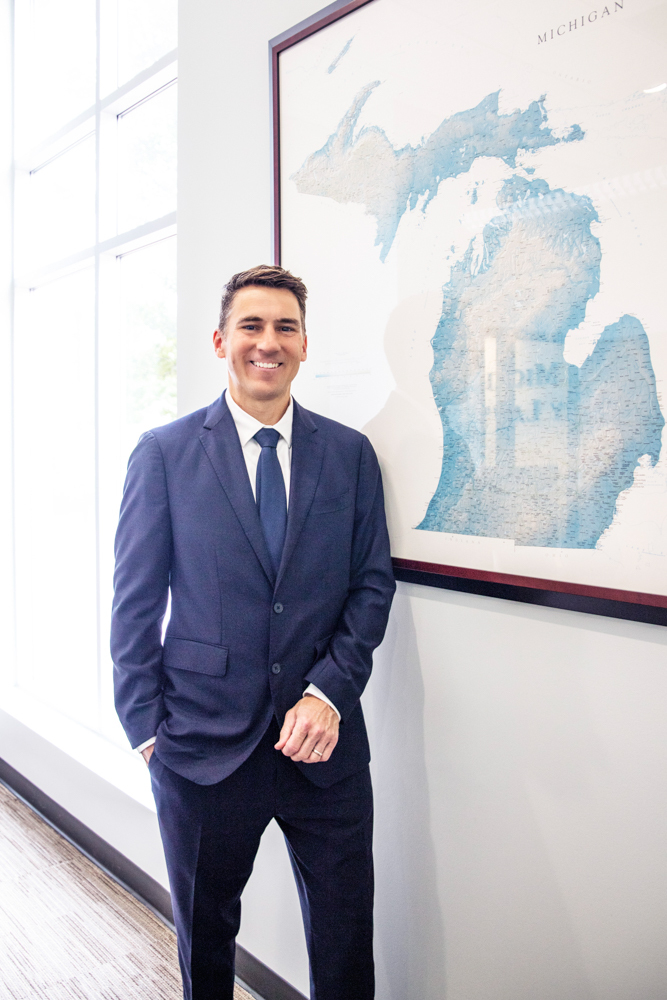 Photo of Personal Injury Attorney David Givskud smiling in front of State of Michigan map
